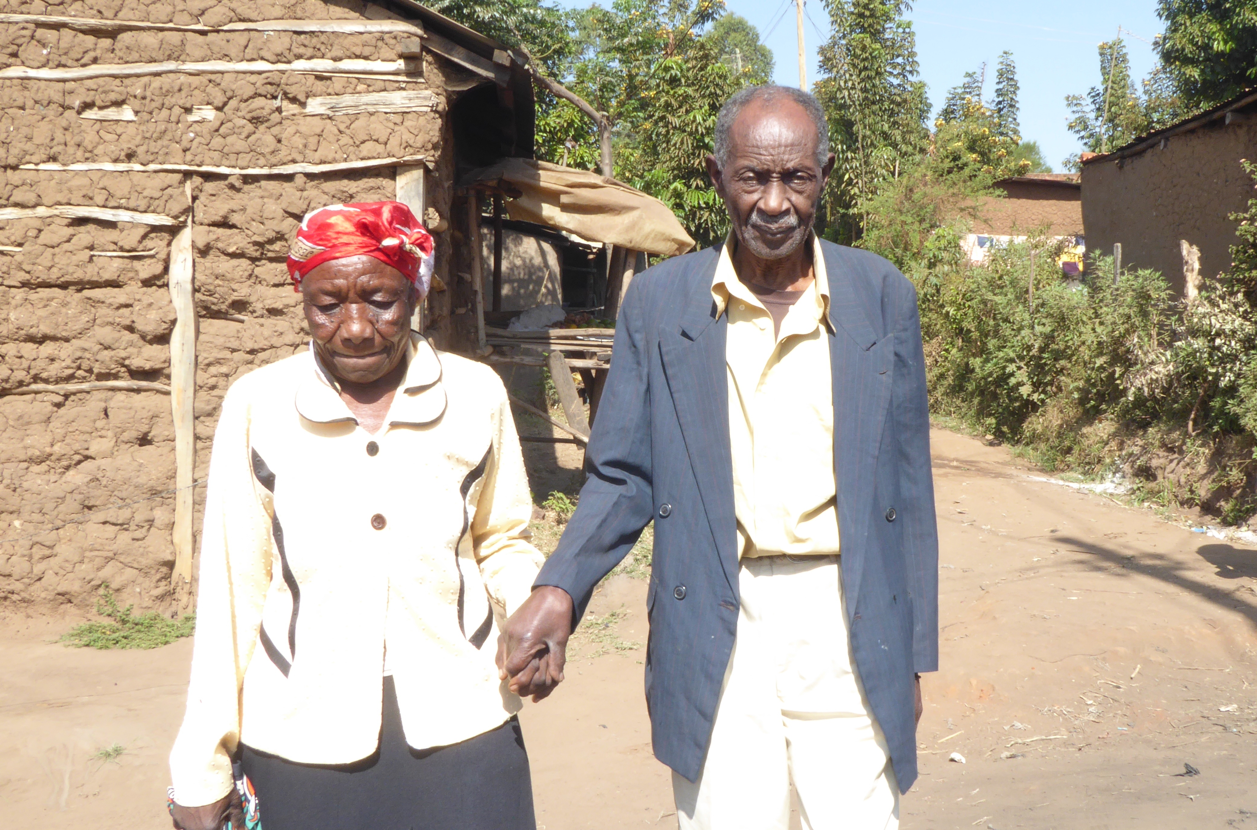 Kenyan couple holds hands as they walk to the car that will take them for sight-saving surgery