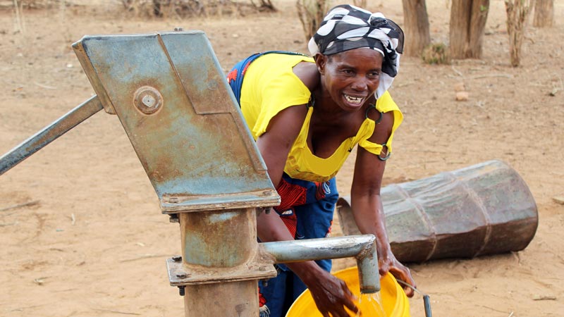 A woman collecting water from a borehole