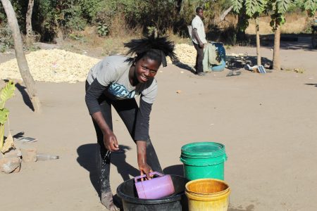 Image of a teenage girl collecting water from water buckets