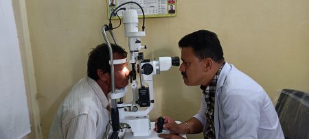 Bitul, an optometrist, measures the refractive error of a patient, using a slip lamp