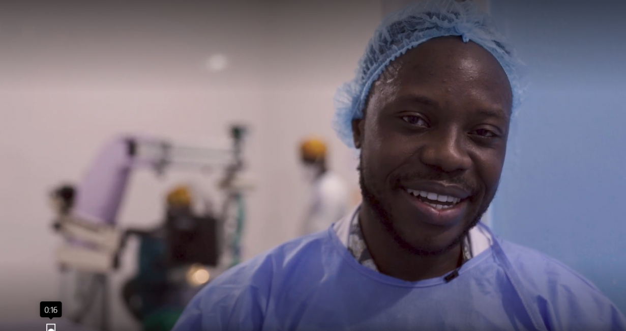 Dr. Geoffrey Wiafe, wearing surgical cap and gown, smiles at the camera