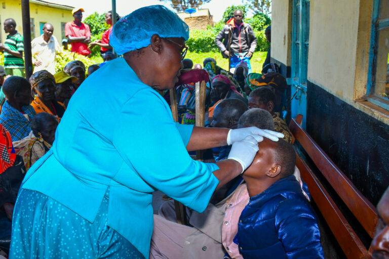 Photo from community eye screening camp as a healthcare personnel attends to the people.