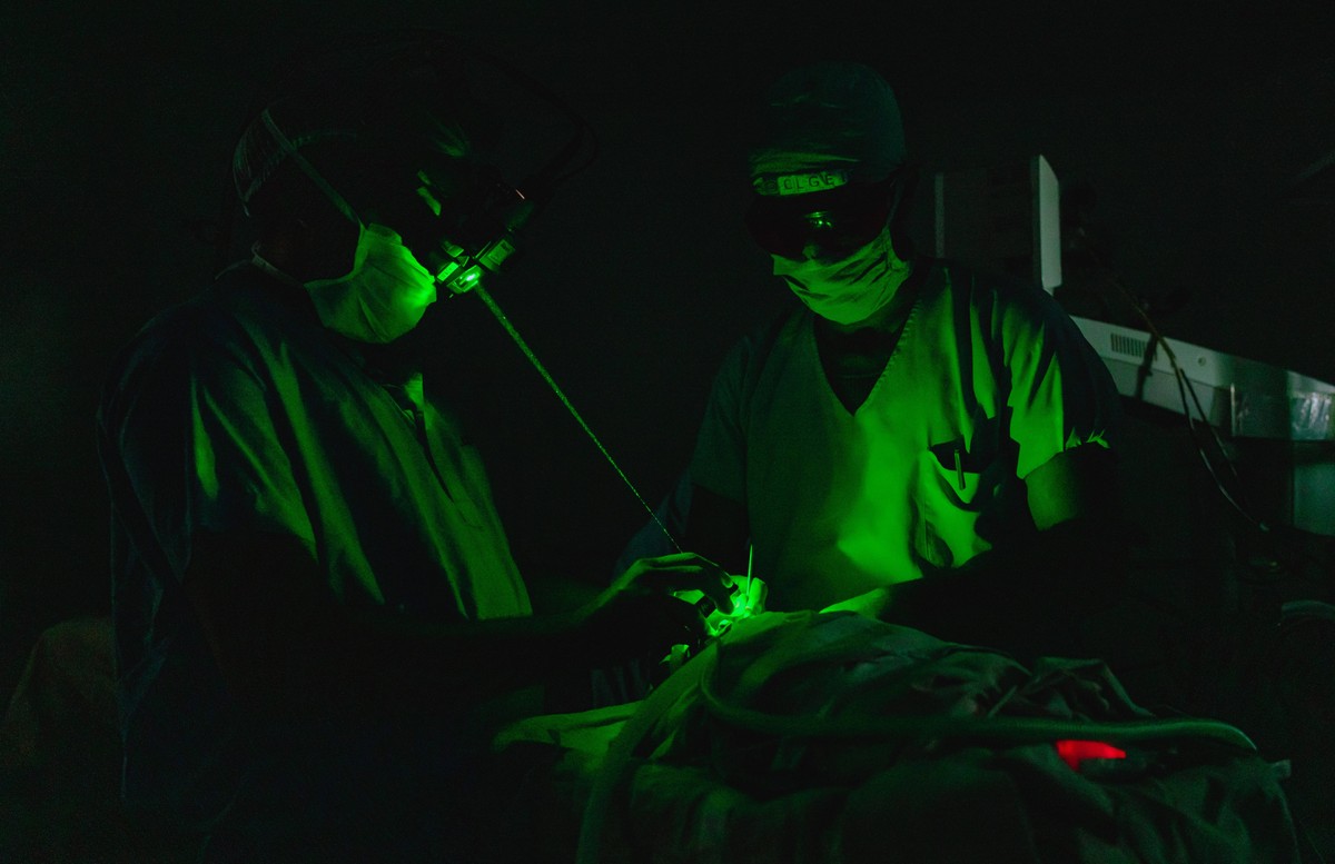 Ophthalmic technicians conduct laser treatment on a premature infant.