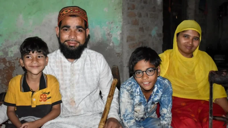 Two boys sit with their parents inside their home.