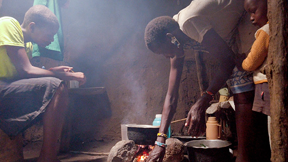 Woman bends over cooking fire with two children by her side.|An elderly woman wearing a blue jacket smiles at the camera.|Community health volunteers screen a young woman for eye conditions in rural Kenya.|Community health volunteers screen a young woman for eye conditions in rural Kenya.|Community health volunteers screen a young woman for eye conditions in rural Kenya.