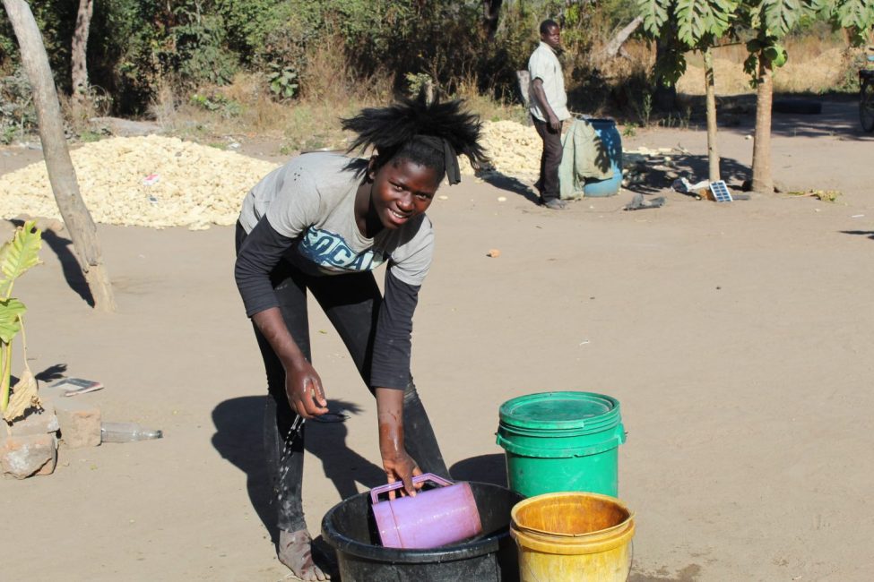 Image of a teenage girl collecting water from water buckets|Group of kids
