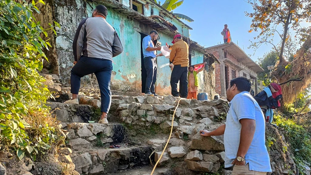 Men climb steep stairs towards a group of houses clustered on a hill.|A woman wearing glasses is drying beans on a roofotp.||Head shot of Emmanuel Benia Tanti.||A man and a woman sit on an outdoor bench together.|A woman wearing a bright orange dress and head wrap poses for the camera.