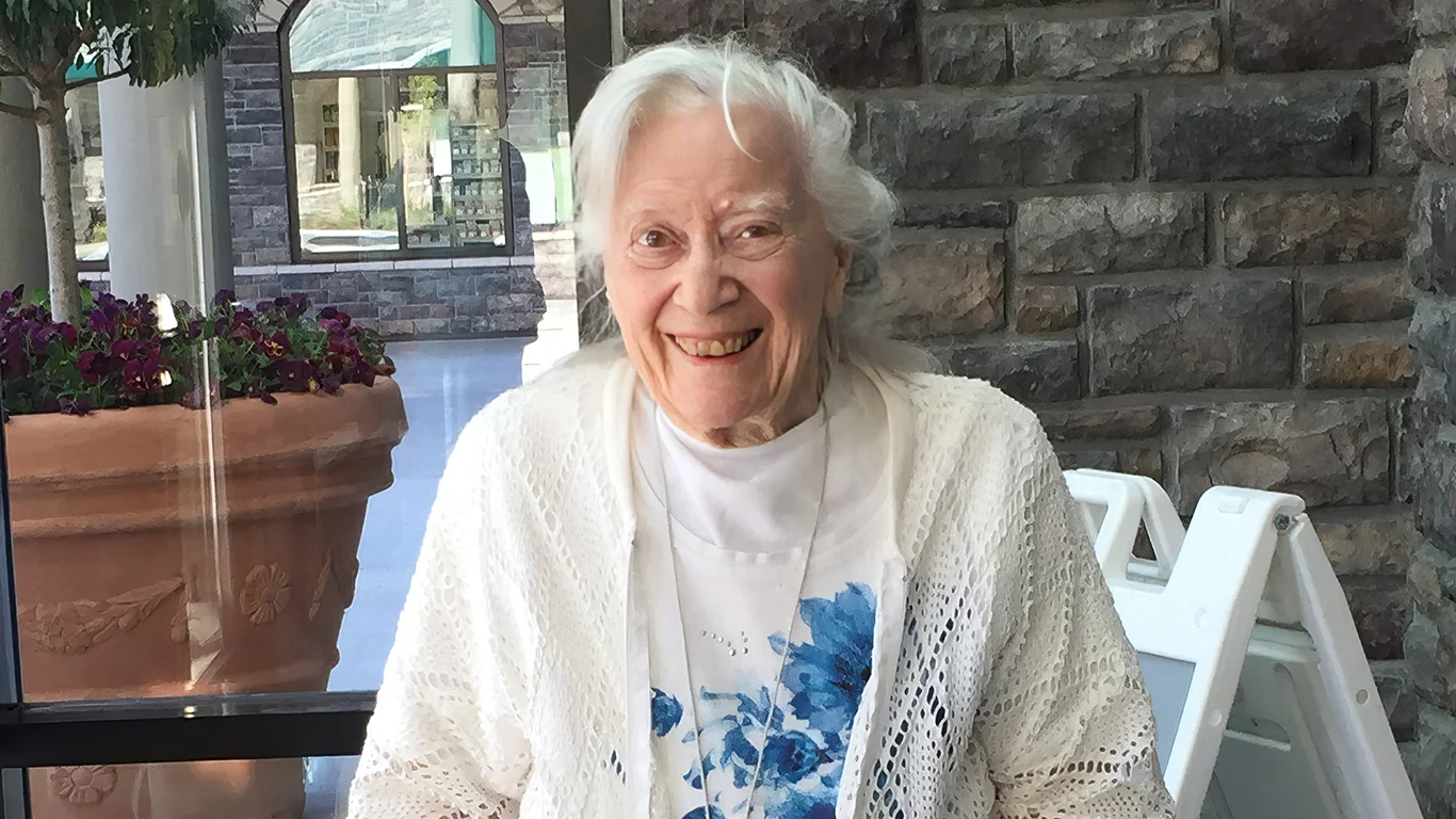 A woman with white hair smiles at the camera.||A woman with white hair smiles at the camera.