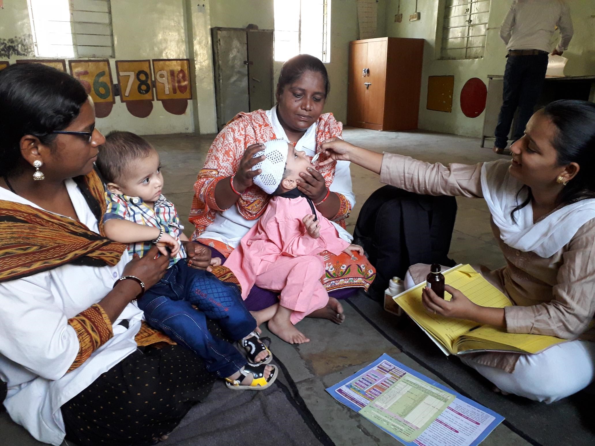 nurses administer vitamin A supplements to child in India|CHW giving polio vaccine to children in India through Operation Eyesight's Hospital-Based Community Eye Health Model